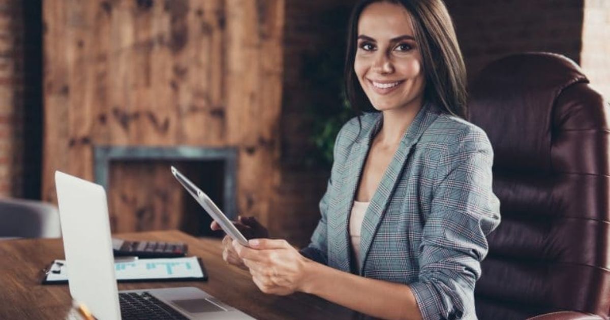 assistante de direction face à un ordinateur avec un stylo dans la main