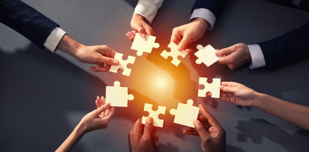 plusieurs mains tenant des pièces de puzzle en rond