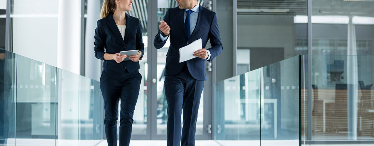 un boss discutant avec sa secrétaire en marchant dans un couloir