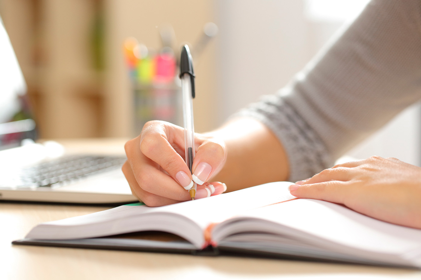 main droite écrivant sur un cahier avec un stylo